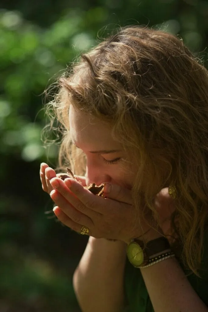 Moteris uosto miško gėrybes. Miško maudynės gamtoje.